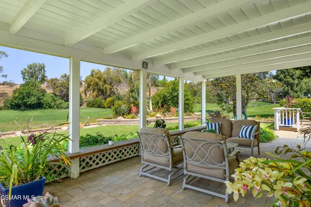 a view of an outdoor sitting area with furniture and garden view