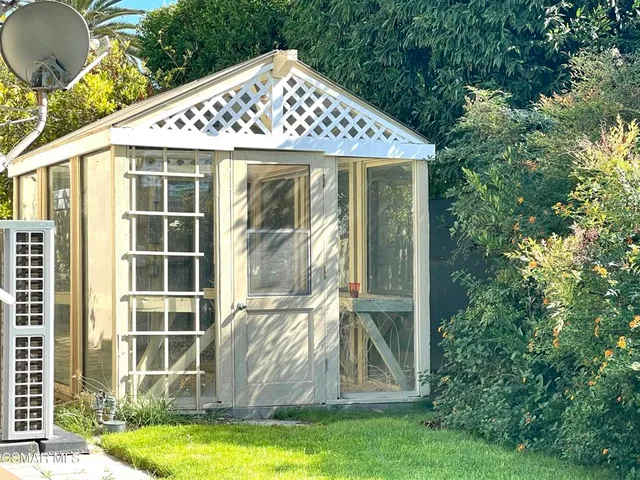 a front view of a house with a yard and potted plants