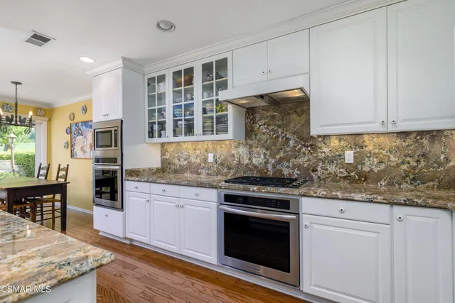 a kitchen with granite countertop cabinets stainless steel appliances and a counter space