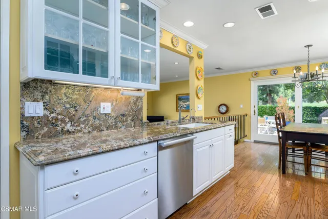 a kitchen with stainless steel appliances granite countertop a sink and wooden cabinets