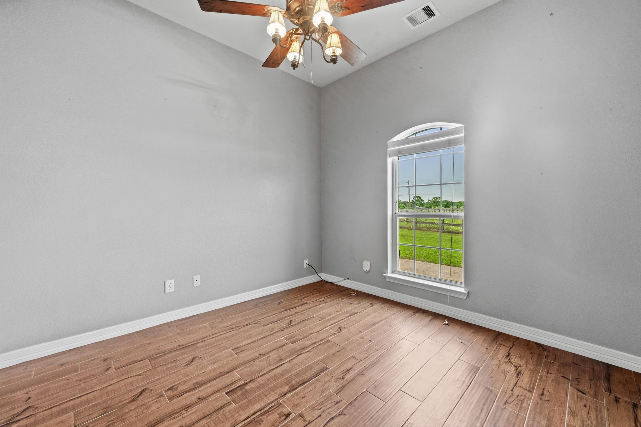 1405 Big Hill Road Winnie, TX 77665 - Photo 18 of 43 a view of an empty room with a window and wooden floor
