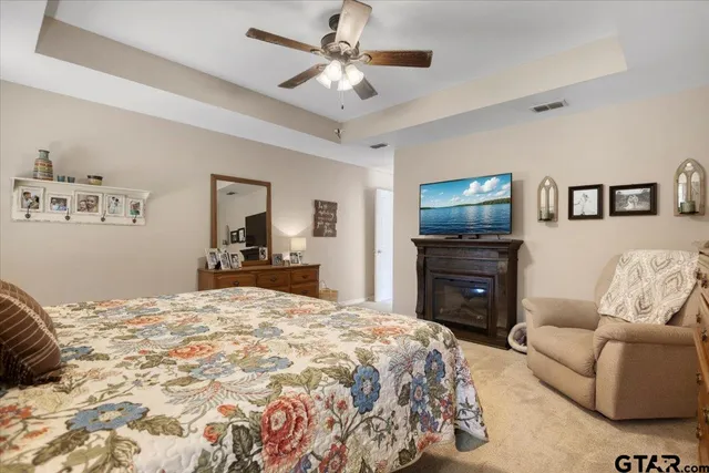 a bedroom with a bed a dresser and a flat screen tv