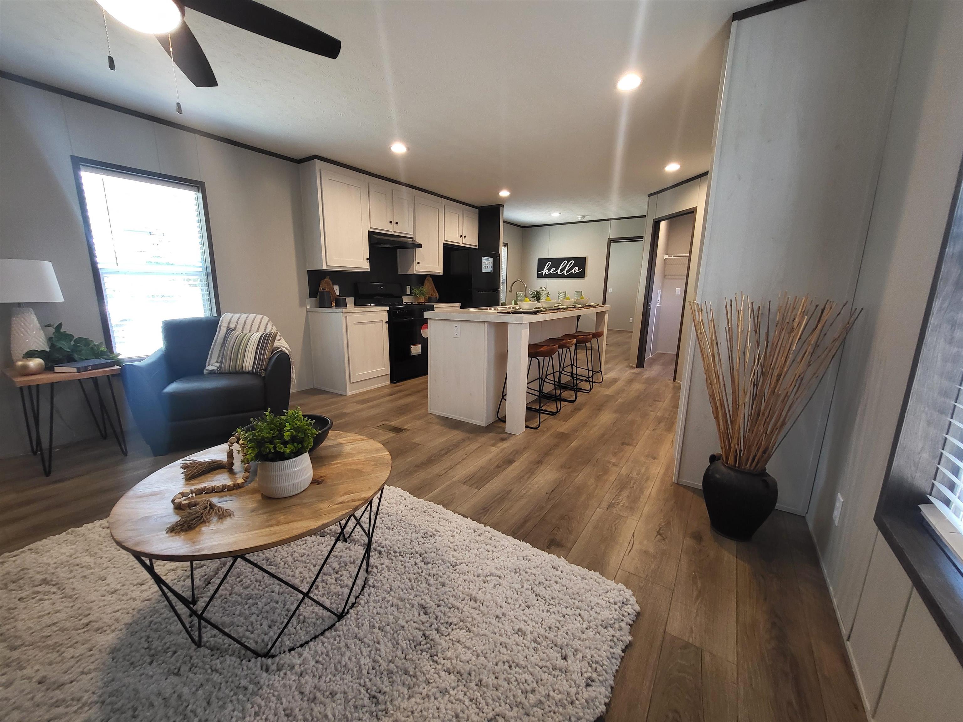 148 Holly Berry Way Fruita, CO 81521 - Photo 3 of 19 a living room with stainless steel appliances furniture a rug kitchen view and a chandelier