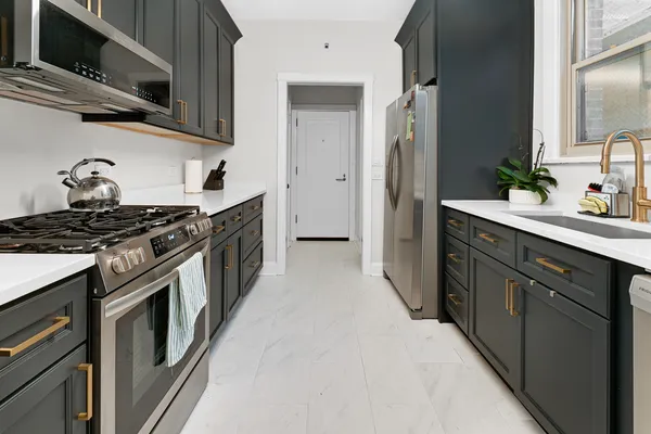 a kitchen with stainless steel appliances granite countertop a stove a sink and a refrigerator