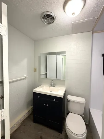 a bathroom with a toilet a sink a mirror and vanity