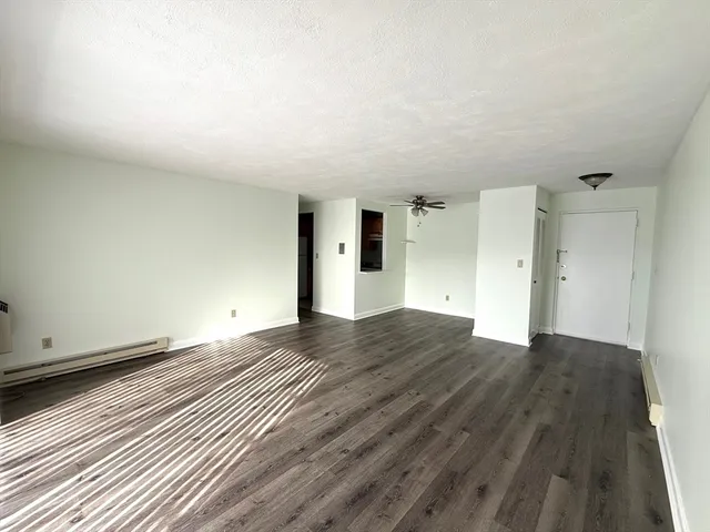 a view of empty room with wooden floor