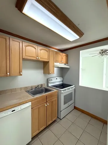 a kitchen with a stove a sink and cabinets