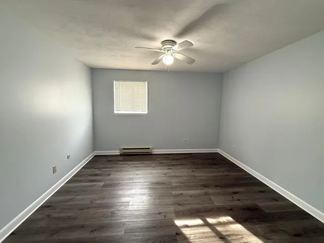 a view of a room with wooden floor and window