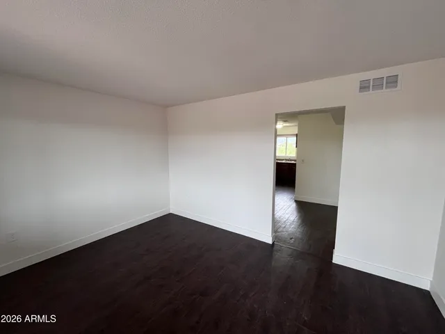 a view of a room has wooden floor and a window