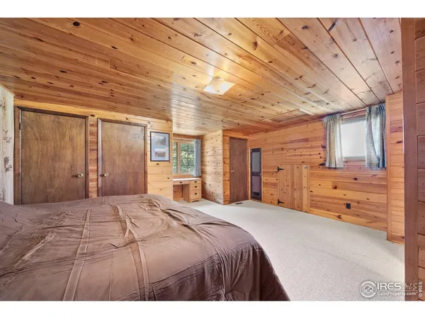 a large bedroom with a large bed and wooden floors