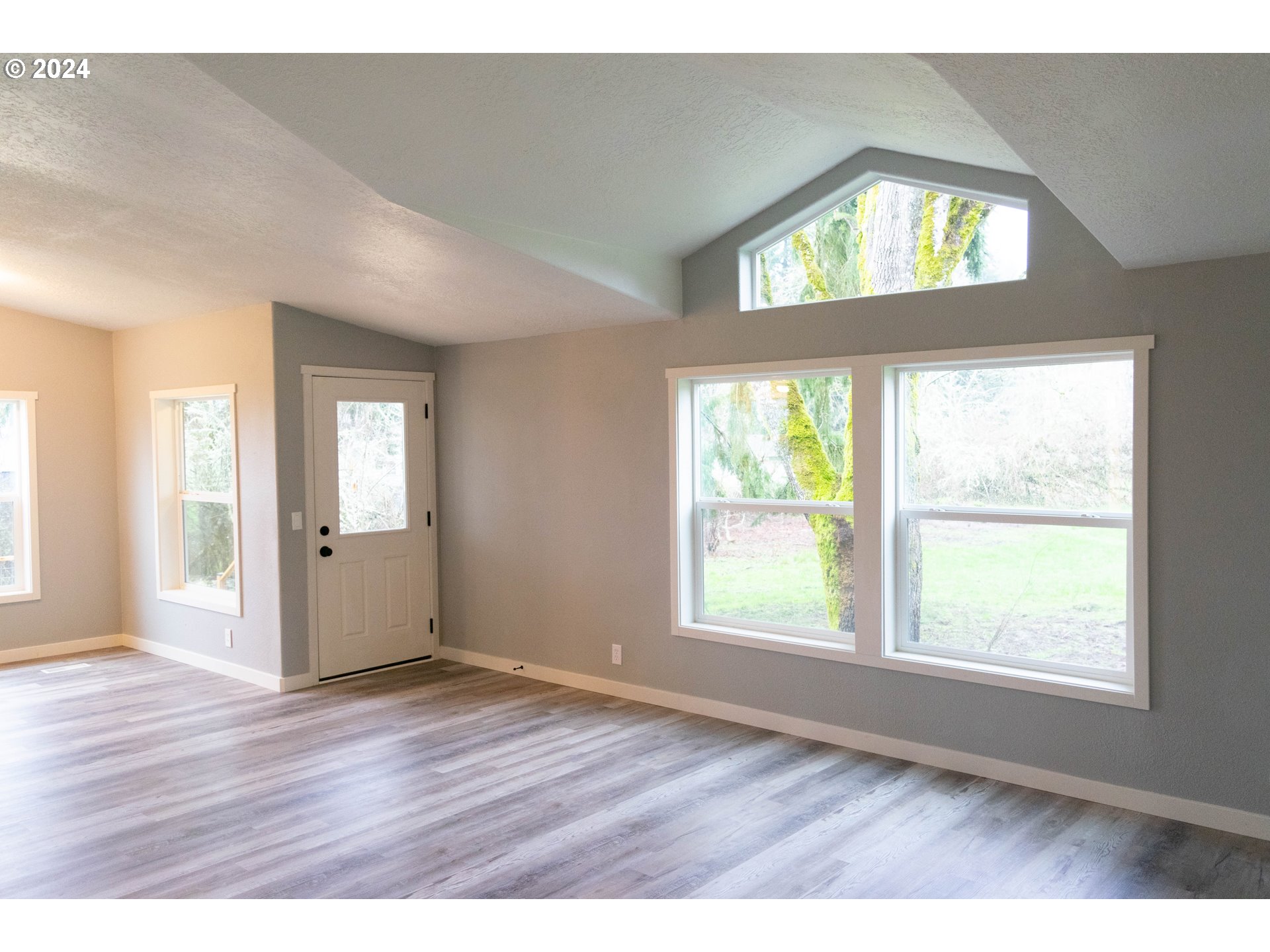 28157 Cottage Grove Lorane Road Cottage Grove, OR 97424 - Photo 3 of 33 an empty room with wooden floor and windows