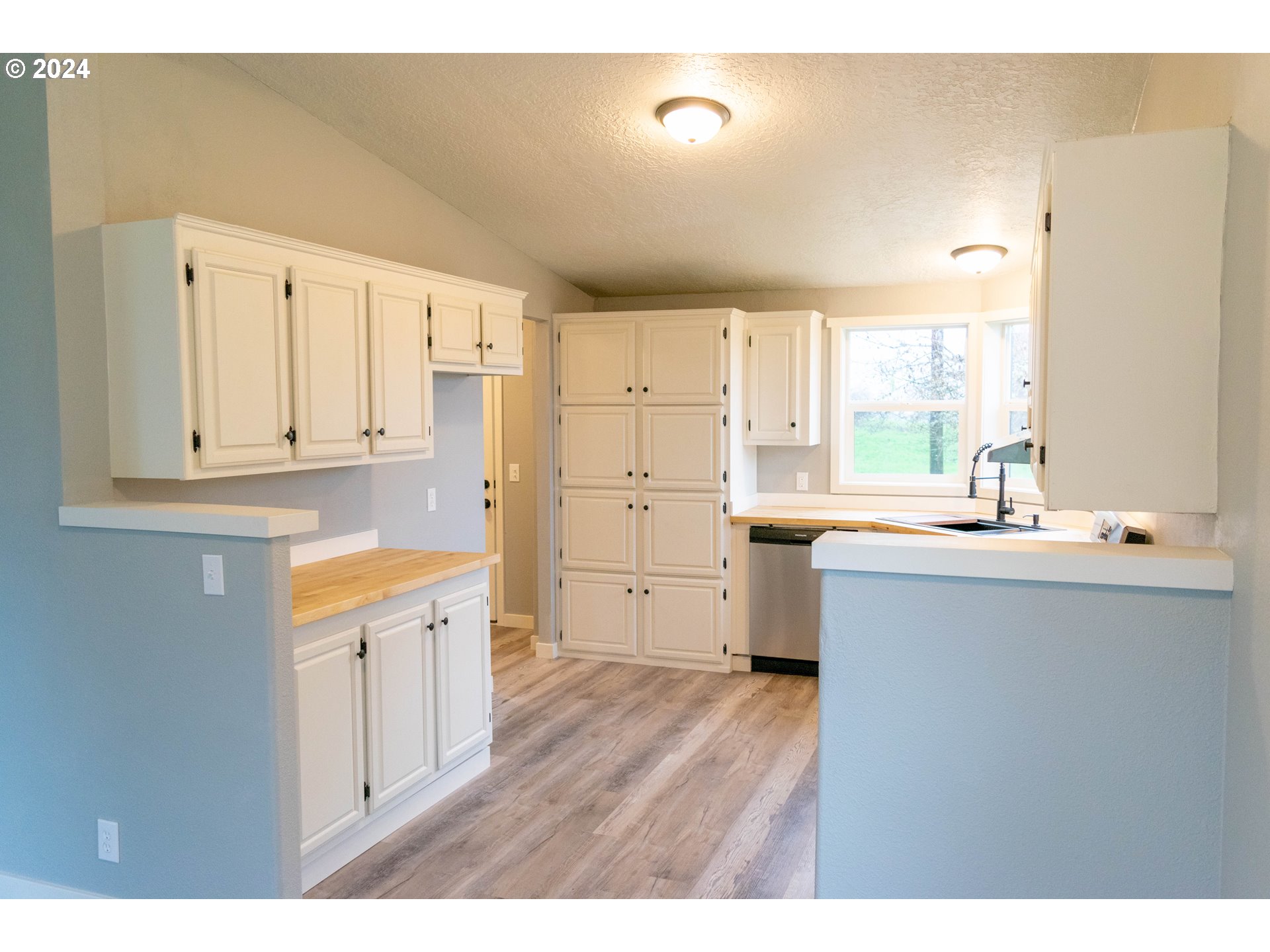 28157 Cottage Grove Lorane Road Cottage Grove, OR 97424 - Photo 6 of 33 a kitchen with granite countertop a sink cabinets stainless steel appliances and a window