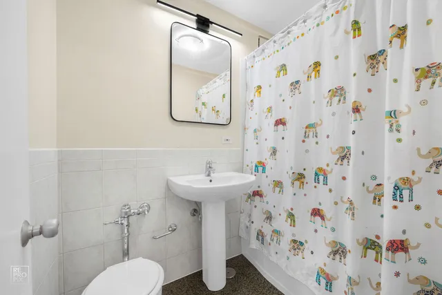 a bathroom with a sink and mirror with toilet