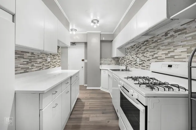 a kitchen with granite countertop a sink stove and cabinets