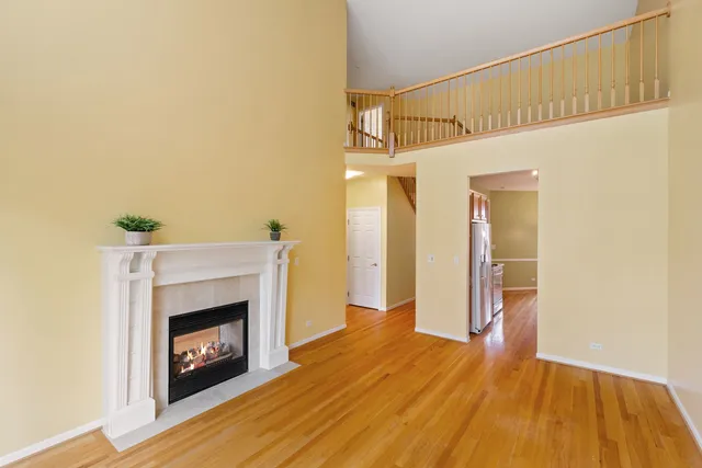 a view of empty room with wooden floor and fireplace