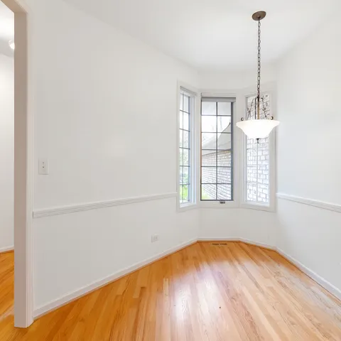 an empty room with windows and ceiling fan