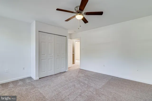 an empty room with closet and fan