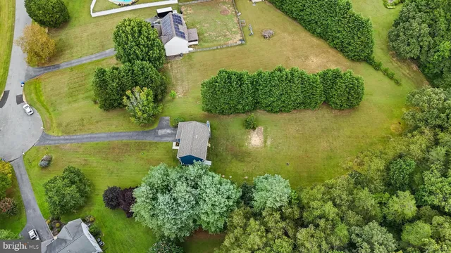 an aerial view of a residential houses with yard