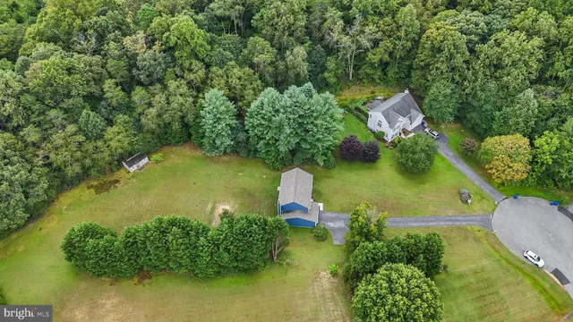 an aerial view of a house with a yard basket ball court and outdoor seating