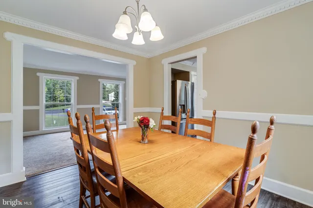 a dining room with furniture a chandelier and wooden floor