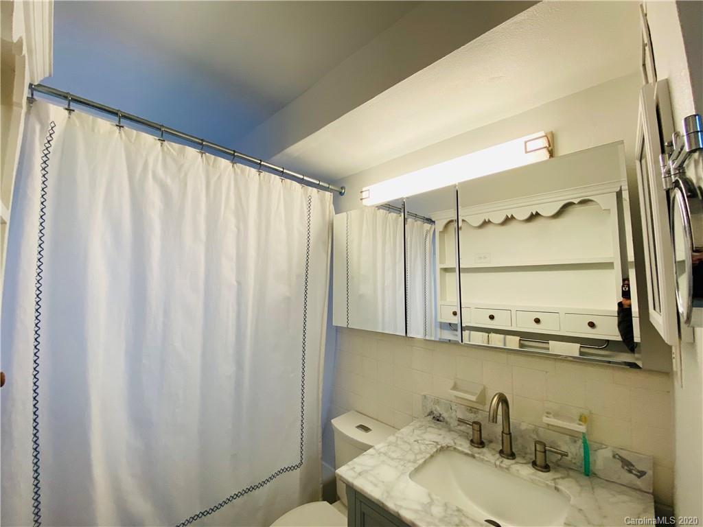 4317 Walker Road, Unit B Charlotte, NC 28211 - Photo 19 of 25 a bathroom with a granite countertop sink and a mirror
