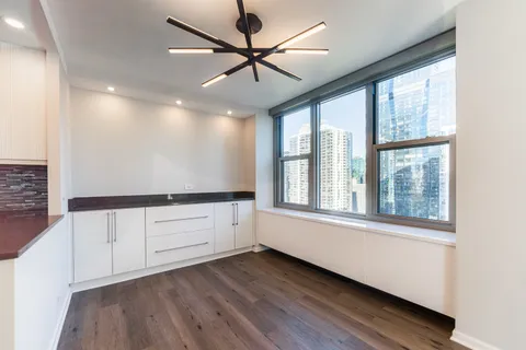 a view of an empty room with window and cabinet