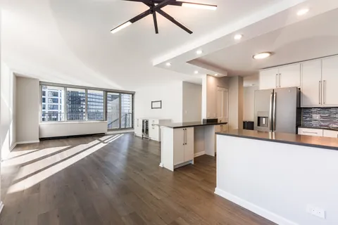 a view of a kitchen with refrigerator and wooden floor