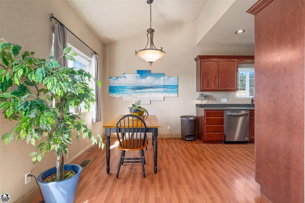 3102 Quail Hill Road Copperopolis, CA 95228 - Photo 11 of 60 a kitchen with stainless steel appliances granite countertop a stove a refrigerator a microwave oven with a dining table and chairs