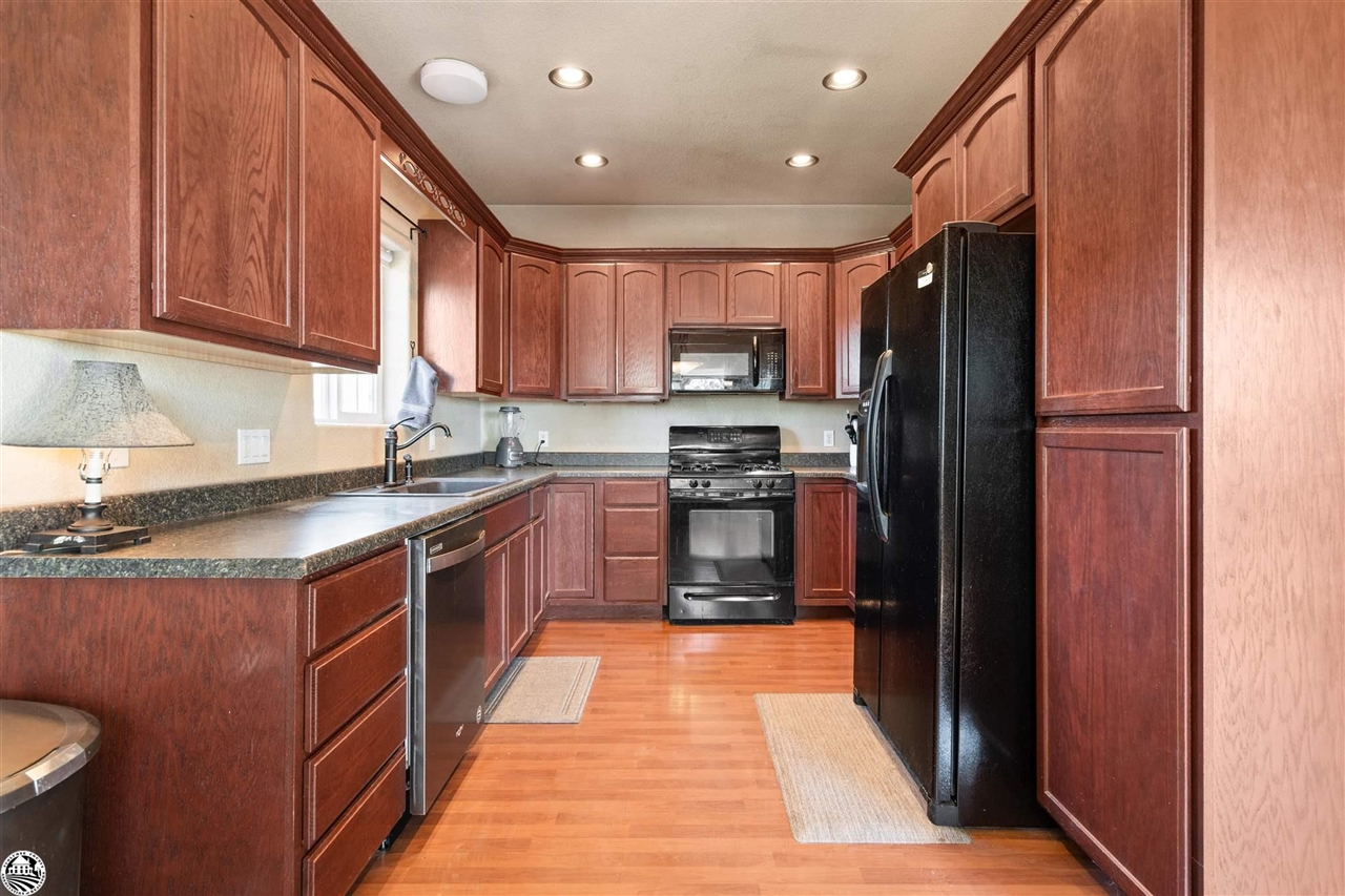 3102 Quail Hill Road Copperopolis, CA 95228 - Photo 13 of 60 a kitchen with stainless steel appliances granite countertop a refrigerator a sink dishwasher and wooden cabinets with a granite countertops