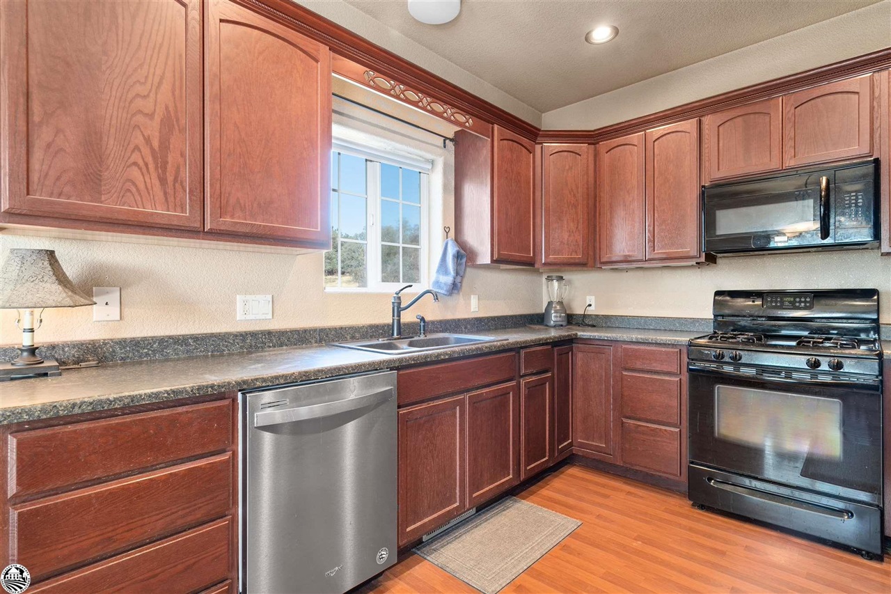 3102 Quail Hill Road Copperopolis, CA 95228 - Photo 14 of 60 a kitchen with stainless steel appliances granite countertop a stove a sink and a microwave