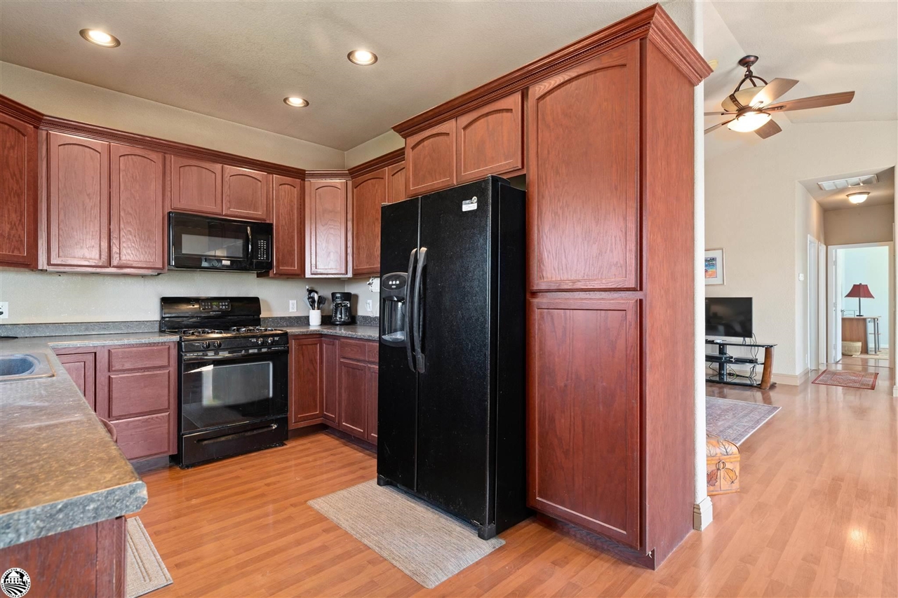 3102 Quail Hill Road Copperopolis, CA 95228 - Photo 15 of 60 a kitchen with granite countertop a refrigerator stove and wooden floor