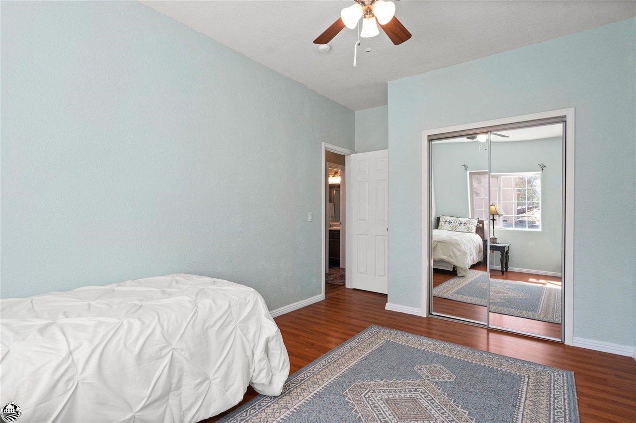3102 Quail Hill Road Copperopolis, CA 95228 - Photo 28 of 60 a bedroom with a bed and a chandelier