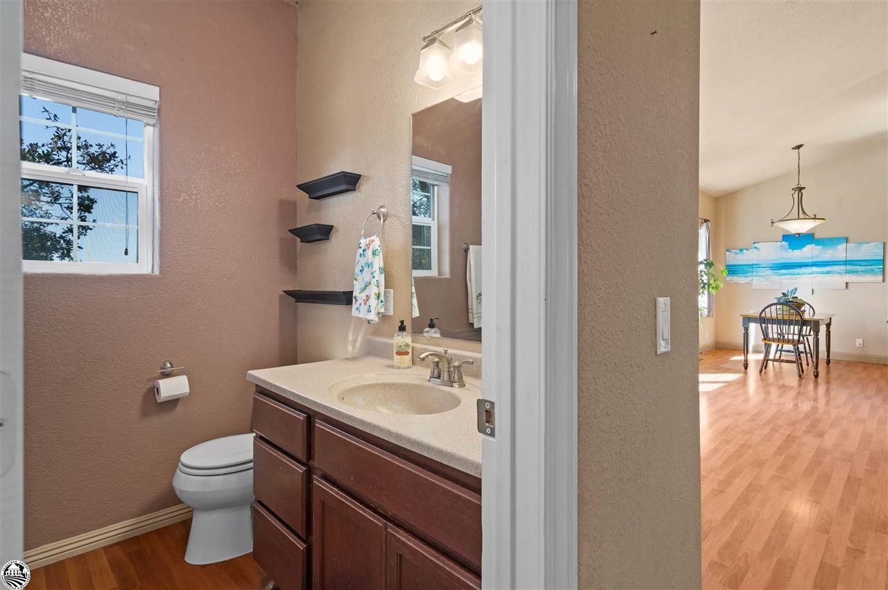 3102 Quail Hill Road Copperopolis, CA 95228 - Photo 31 of 60 a bathroom with a toilet a sink and mirror