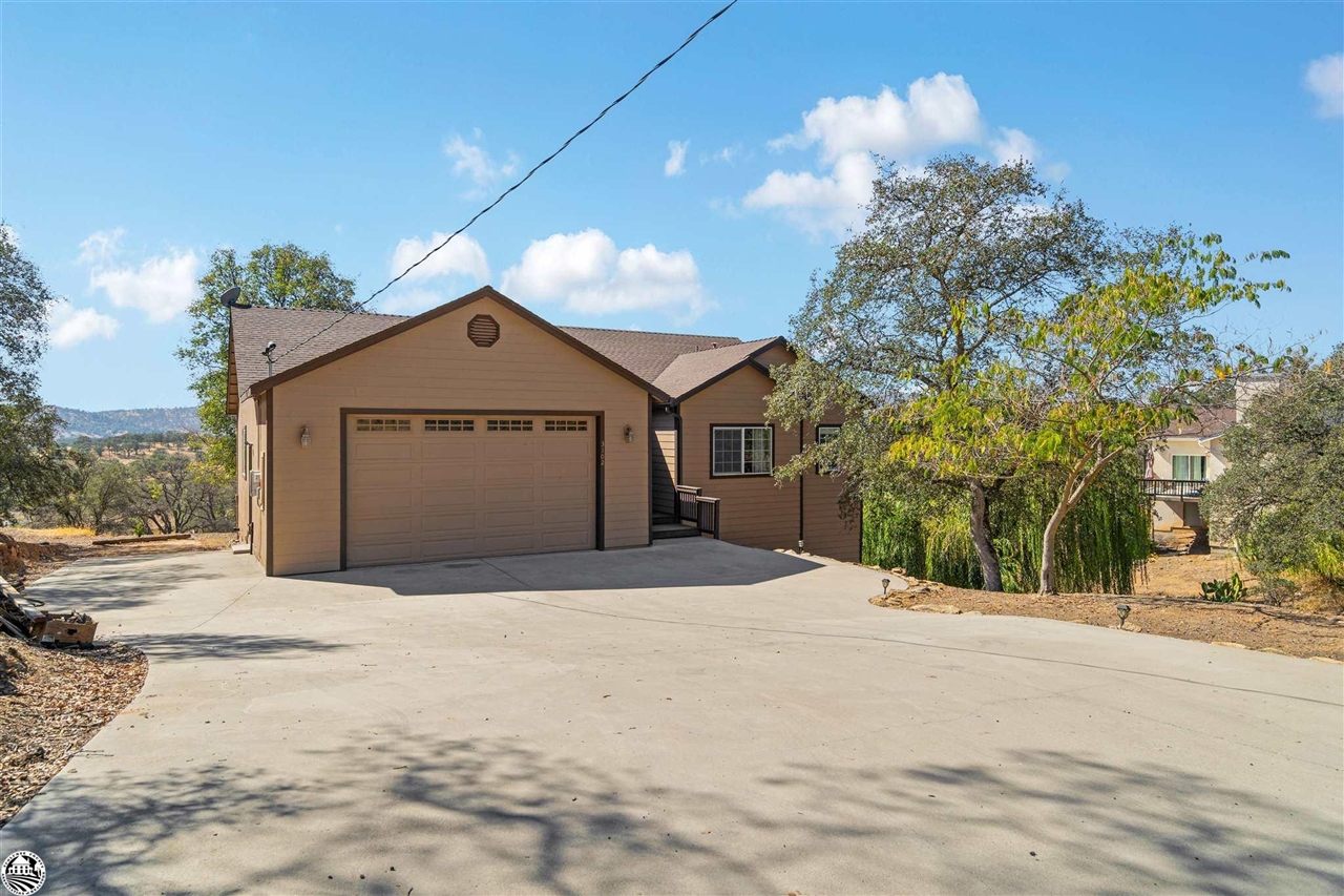3102 Quail Hill Road Copperopolis, CA 95228 - Photo 49 of 60 a front view of a house with a yard and garage