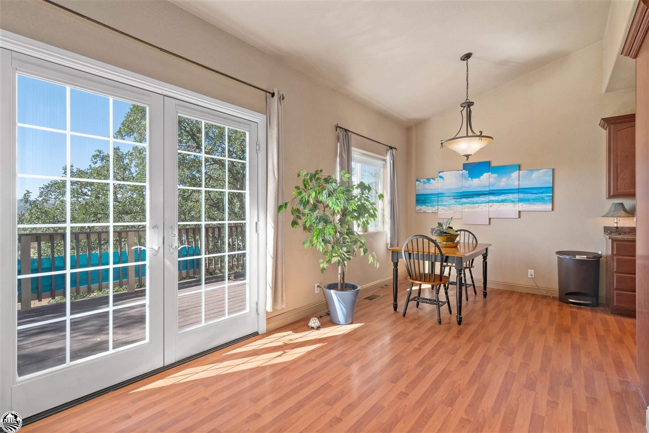 3102 Quail Hill Road Copperopolis, CA 95228 - Photo 10 of 60 a dining room with wooden floor a chandelier a glass table and chairs
