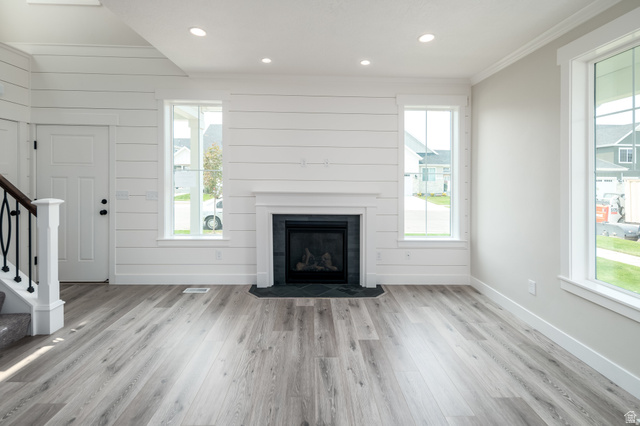 801 East Cys Road, Unit 19 Sandy, UT 84094 - Photo 2 of 11 Living space featuring a shiplap accent wall, a white mantel fireplace with dark stone surround, and wood-finish flooring