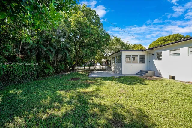 a view of a house with backyard and sitting area