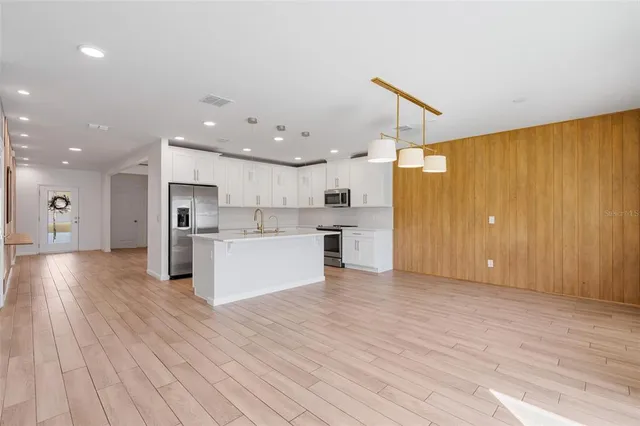 a large kitchen with stainless steel appliances kitchen island a large counter space a sink and appliances