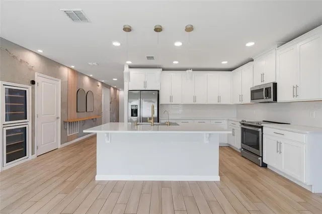 a large kitchen with a large counter top appliances and cabinets