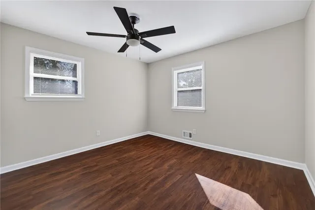 a view of room with wooden floor and ceiling fan
