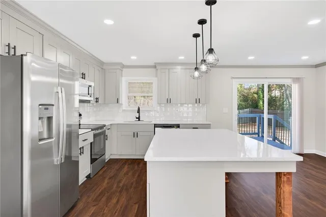 a kitchen with stainless steel appliances a refrigerator sink and stove