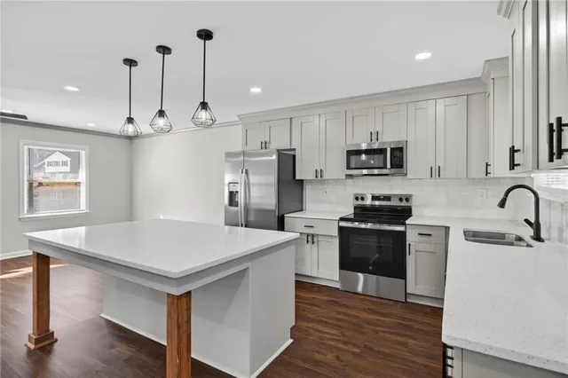 a kitchen with kitchen island a wooden floor and white cabinets