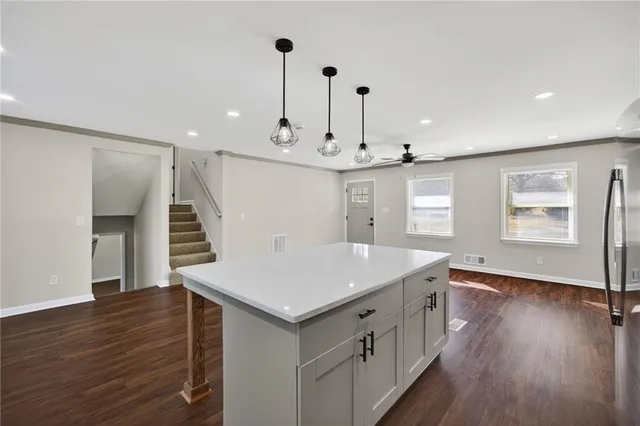 a kitchen with a sink and wooden floor
