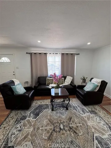 a living room with furniture a rug and a window