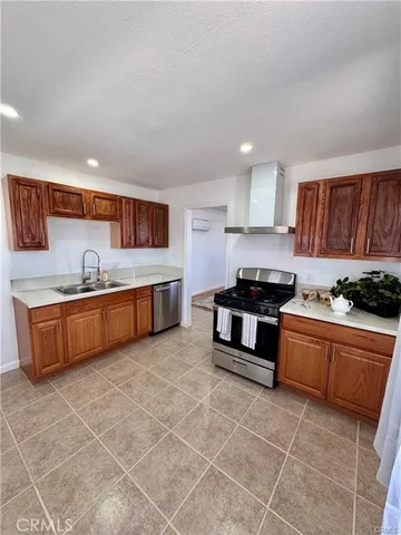 a kitchen with stainless steel appliances granite countertop a stove a sink and a refrigerator