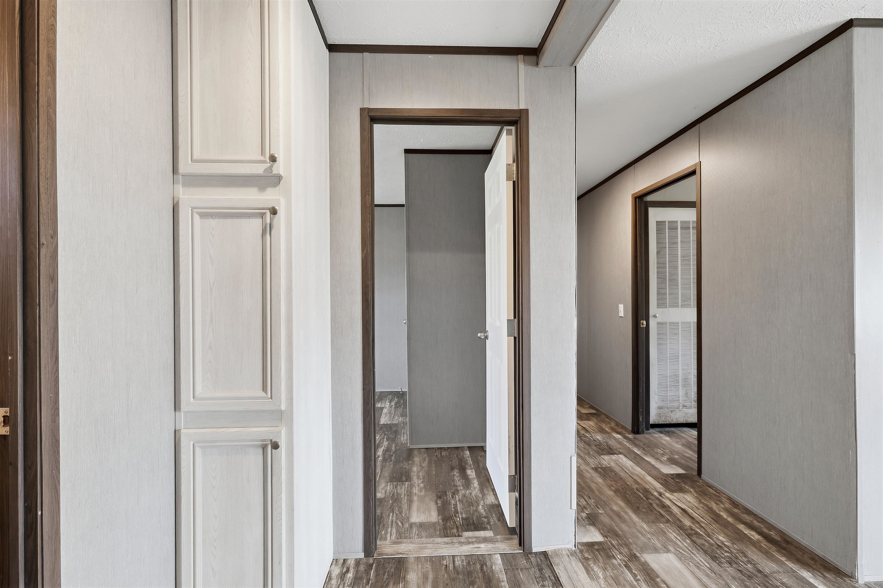 664 Rialto Road Covington, TN 38019 - Photo 13 of 24 Wood-finish flooring throughout, light-toned walls, built-in cabinetry with paneling, dark trim accents, and white interior doors