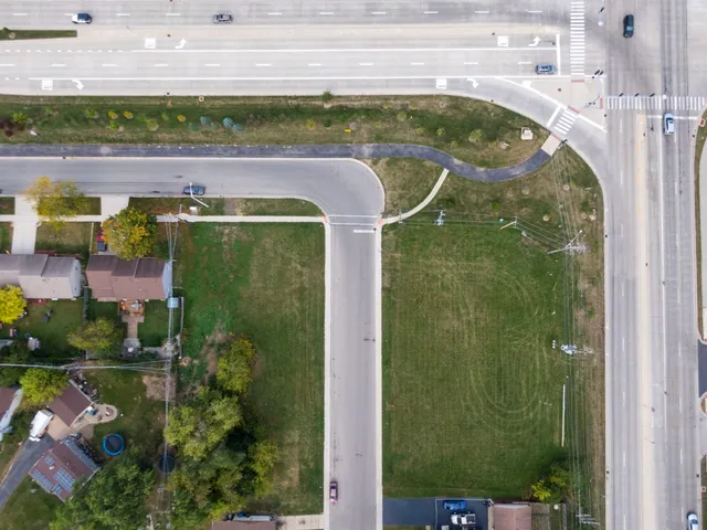 an aerial view of a residential houses with outdoor space and street view