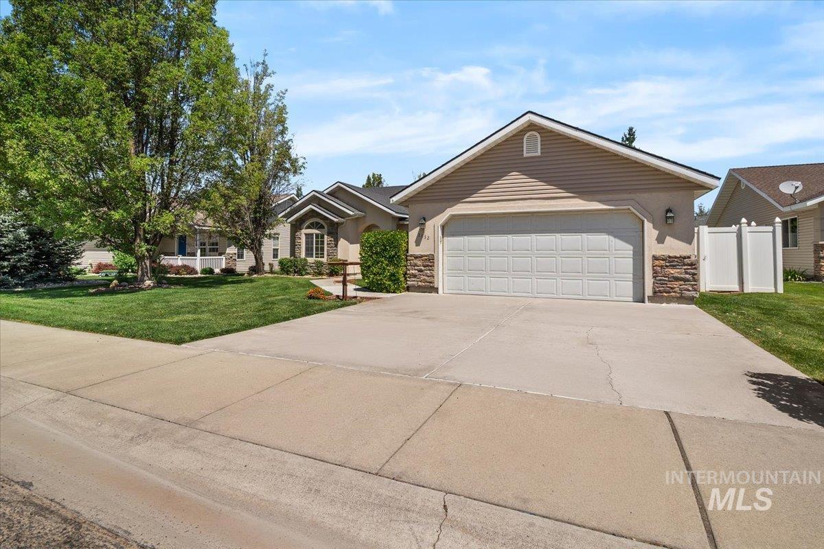 2032 Talus Loop Twin Falls, ID 83301 - Photo 5 of 43 Single-story residence featuring a two-car garage with a paneled door, stone accents on the facade, and beige siding