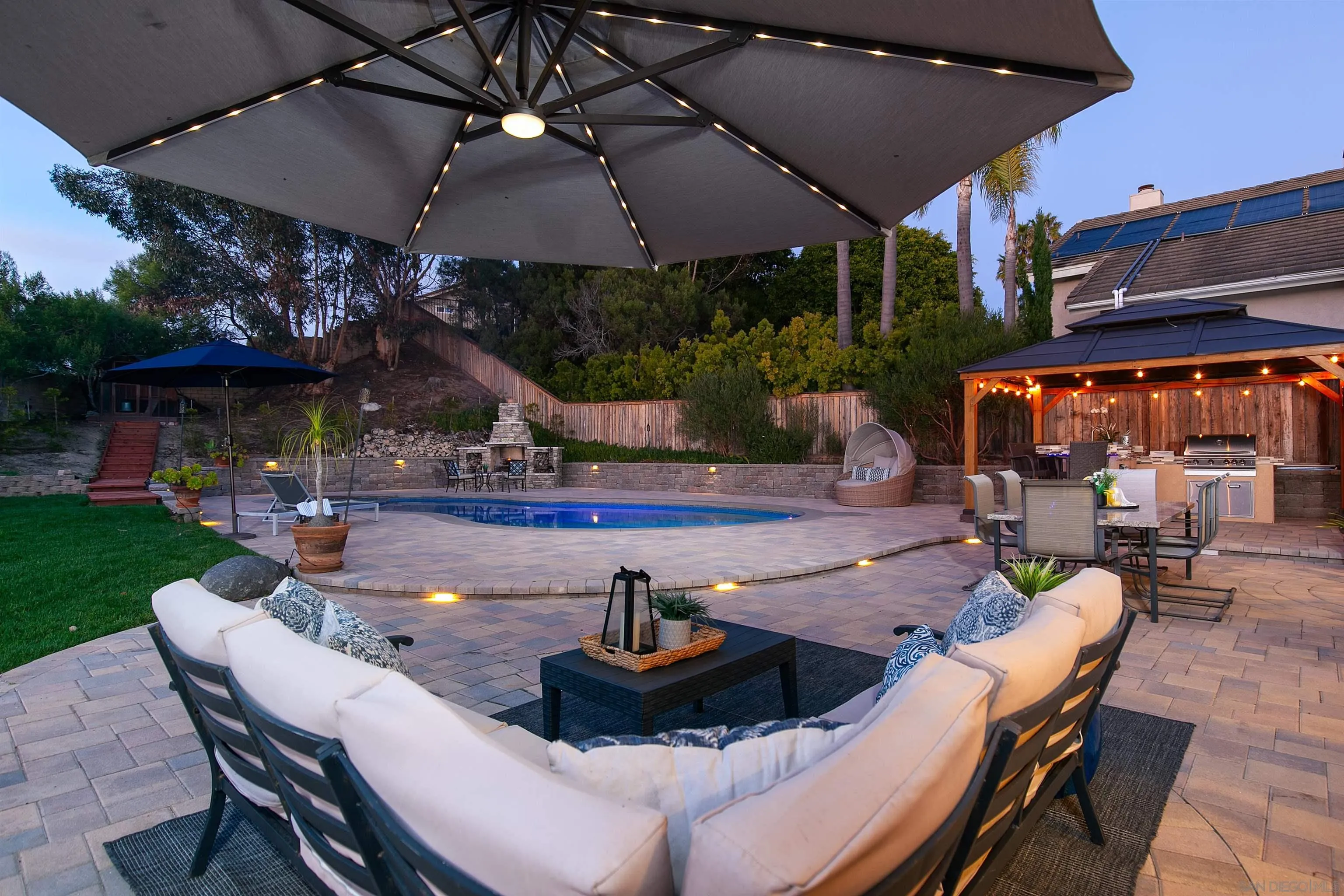 3245 Lower Ridge Road San Diego, CA 92130 - Photo 37 of 45 a view of a patio with table and chairs under an umbrella