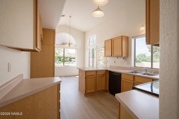a large kitchen with lot of cabinets and wooden floor